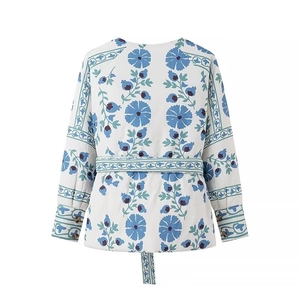 Détails du dos d'une veste en coton à fleurs blanches et bleues avec une ceinture assortie