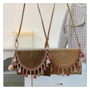 Detailed shot of bohemian straw crossbody bags with colorful tassels in coffee and beige