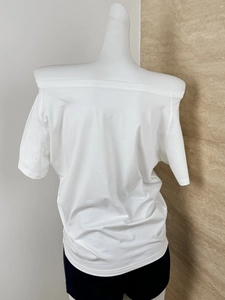Detailed view of the white off-shoulder cotton t-shirt with loose drape and layered design