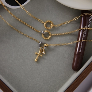 Detail of 18K gold stainless steel cross pendant necklace with silver bicolor ring clasp