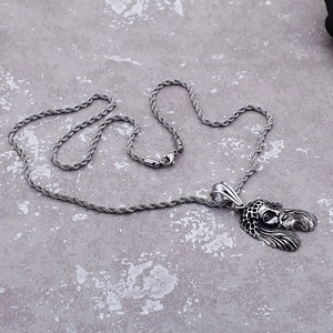Detailed view of silver lion head pendant with textured twist chain on grey stone