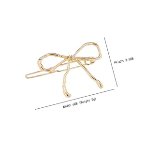 Elegant gold bow hair clip with dimensions 6cm by 3.5cm on a white background