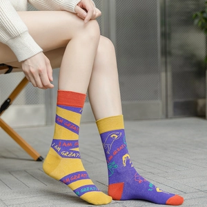 Detail of asymmetrical mid-calf socks featuring creative silhouette patterns and 'I AM GREAT' text