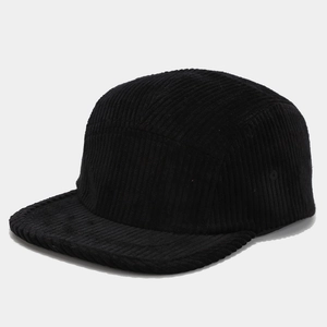 Detailed texture of black corduroy fabric on a 5-panel camper hat with flat brim