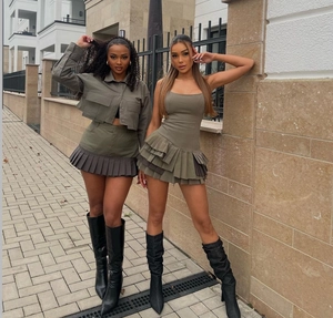 Detailed view of olive green pleated mini dress and utility jacket with street style texture
