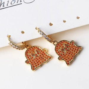 Macro view of gold Halloween ghost earrings with orange and clear cubic zirconia stones