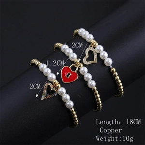 Detailed view of pearl and gold bead bracelets featuring enamel heart and zircon charms