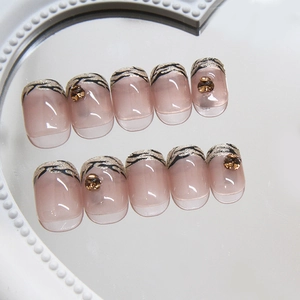 Unghie finte French nude rosa con motivo leopardato e glitter dorati minimalisti