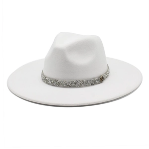Detail of white wool fedora hat featuring a silver rhinestone band and golden M metal logo