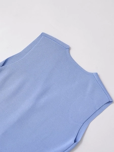 Détail de la texture en maille bleu clair et des finitions de qualité sur ce gilet