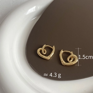 Close-up showing 1.5cm size and 4.3g weight of gold-plated twisted heart earrings