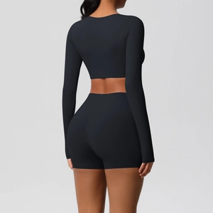Back view of a two-piece black yoga set with high-waisted shorts and crop top sleeves