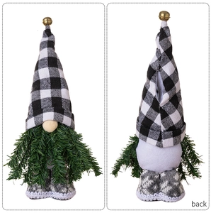 Dettaglio bambola gnomo di Natale con cappello a quadri e barba di aghi di pino.