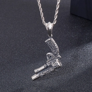 Detailed close-up of a vintage punk silver revolver pistol pendant with an ornate pattern