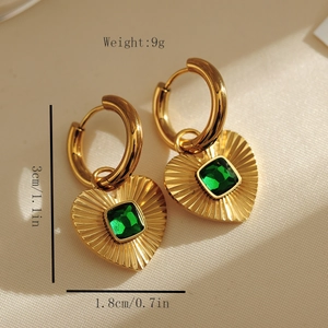 Détail de boucles d'oreilles créoles plaquées or 18 carats avec pendentif cœur émeraude