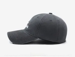 Side view detail of a washed grey baseball cap with vintage finish and white embroidery