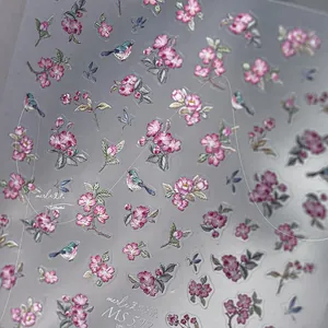 Macro detail of embossed nail art stickers MS 592 with pink flowers and bird motifs