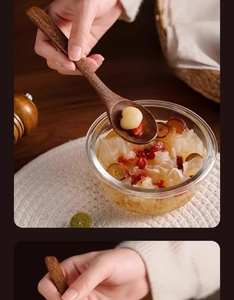 Close-up of a long-handled natural wood spoon for soup and desserts with warm home lighting