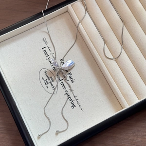 Close-up of elegant butterfly pearl necklace with rhinestones in a luxury jewelry box