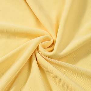 Macro detail of breathable light yellow knitted mesh fabric showing texture and softness