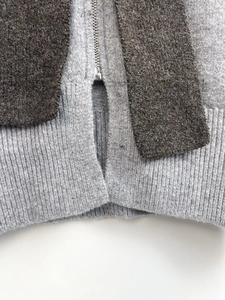 Close-up of contrast knit sweater featuring ribbed hem and durable metal zipper detail