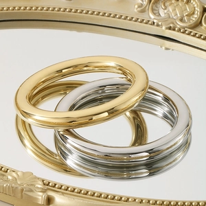 Minimalistische 18K gold- und silberpolierte Hohlarmbänder auf einem Vintage-Spiegel
