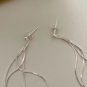 Detail of 925 sterling silver long tassel drop earrings with sleek snake bone chains