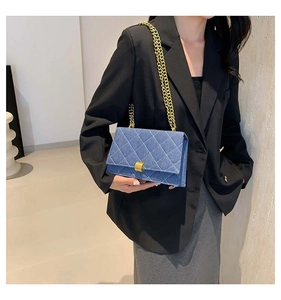 Blue denim crossbody bag featuring quilted patterns and a gold chain strap for women