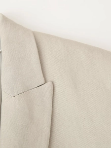 Detail of beige sleeveless vest collar with refined woven texture and clean stitching