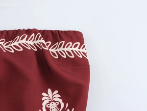 Detail of bohemian ethnic print waist and wine red woven fabric on maxi dress