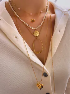Detailed layered golden necklace set with heart pendant and mother of pearl beads