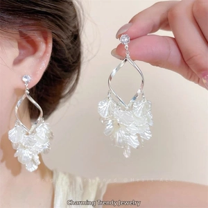 Gros plan de boucles d'oreilles en argent avec zircons et coquilles blanches