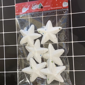Close-up of white glittery foam star ornaments in transparent plastic packaging for Christmas