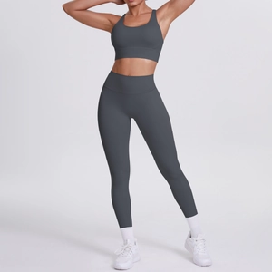Ensemble de yoga gris foncé avec brassière croisée et legging taille haute sur modèle