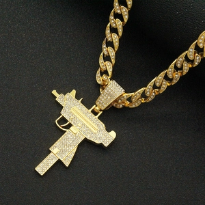 Iced out gold Cuban link necklace with rhinestone studded submachine gun pendant