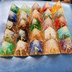 Macro view of crystal resin pyramids with crushed stones and golden mystical symbols