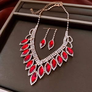 Detailed view of red marquise-cut crystal necklace and earrings set in a gift box