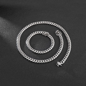 Flat lay of 8mm silver stainless steel Cuban link necklace and bracelet jewelry set