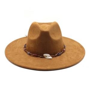 Close-up of brown suede fedora featuring bohemian beaded band and shell centerpiece