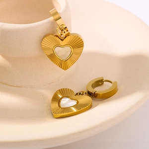 Elegant gold heart earrings with white mother-of-pearl inlay and sunburst texture