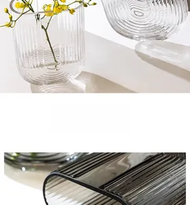 Detailed view of modern U-shaped glass vase with vertical ribbed texture and smooth rim
