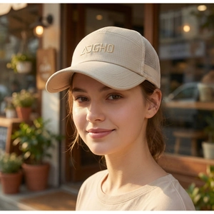 Detail of beige mesh baseball cap featuring AJGHO embroidery and lightweight grid fabric