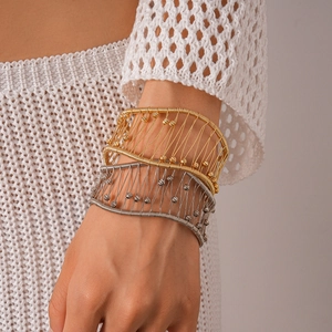 Gros plan de bracelets tressés en or et argent avec des détails de perles métalliques