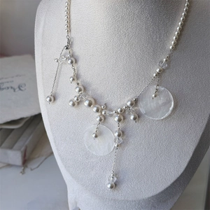 Detail of shell pendant necklace with pearls and crystal beads on a velvet bust