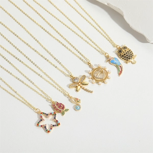 Close-up of bohemian gold charm necklaces with owl, heart, and eye pendants
