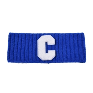 Détail d'un bandeau en maille bleue avec écusson brodé lettre C blanc et texture côtelée
