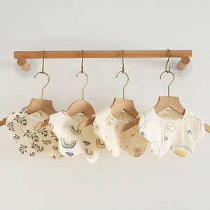 Hanging set of four soft petal-shaped cotton gauze baby bibs with cute cartoon prints