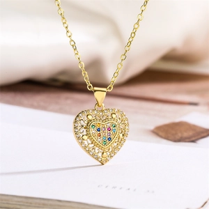 Macro detail of gold heart pendant with colorful crystals and sparkling zircon border