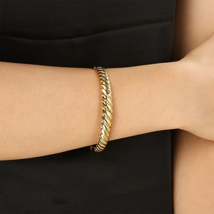 Detailed view of the twisted rope texture on a high-shine gold titanium steel bangle
