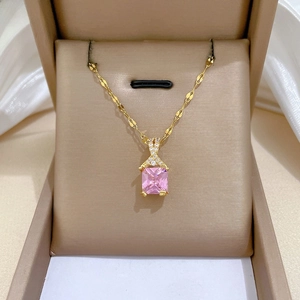 Close-up of sparkling pink square gemstone pendant with crisscross diamond-set detail